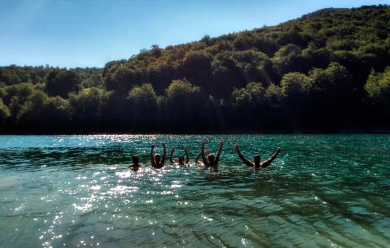 Personas disfrutando de un baño en el lago de la Selva de Irati tras la práctica de yoga durante el Retiro del puente Agosto en el Pirineo Navarro