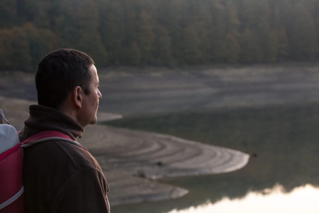 Jon contemplant l'eau au coucher du soleil dans les Pyrénées navarraises
