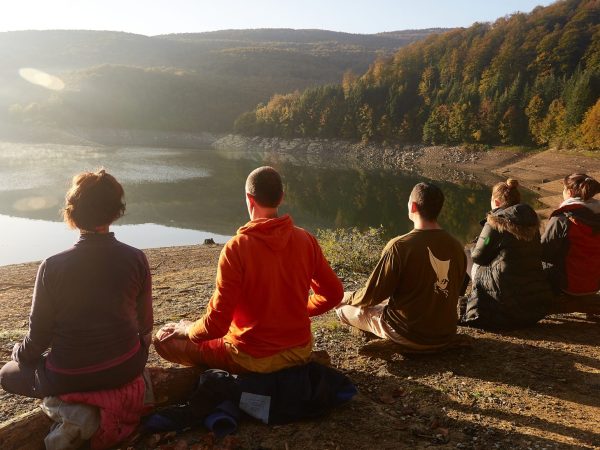 a group of people standing in front of a mountain