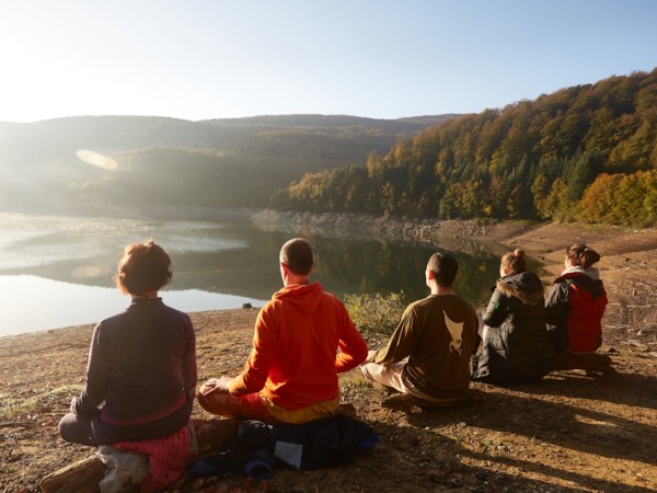 a group of people sitting in front of a mountain