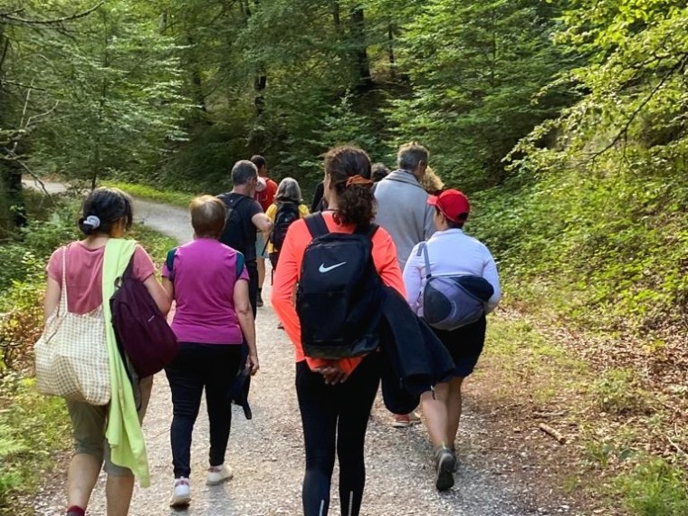 a group of people walking down a dirt road