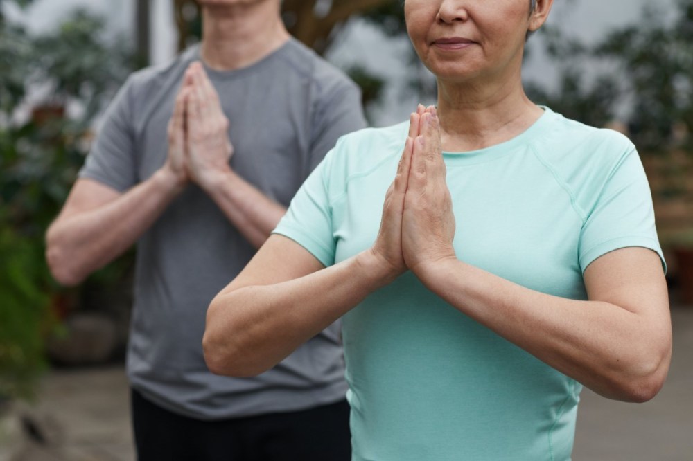 Mujer y hombre practicando yoga para parejas durante el retiro en San Valentin