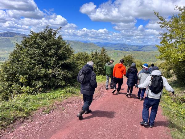 a group of people walking down a dirt road