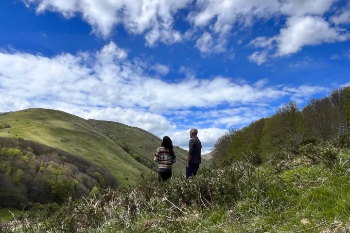 a man standing on a grassy hill