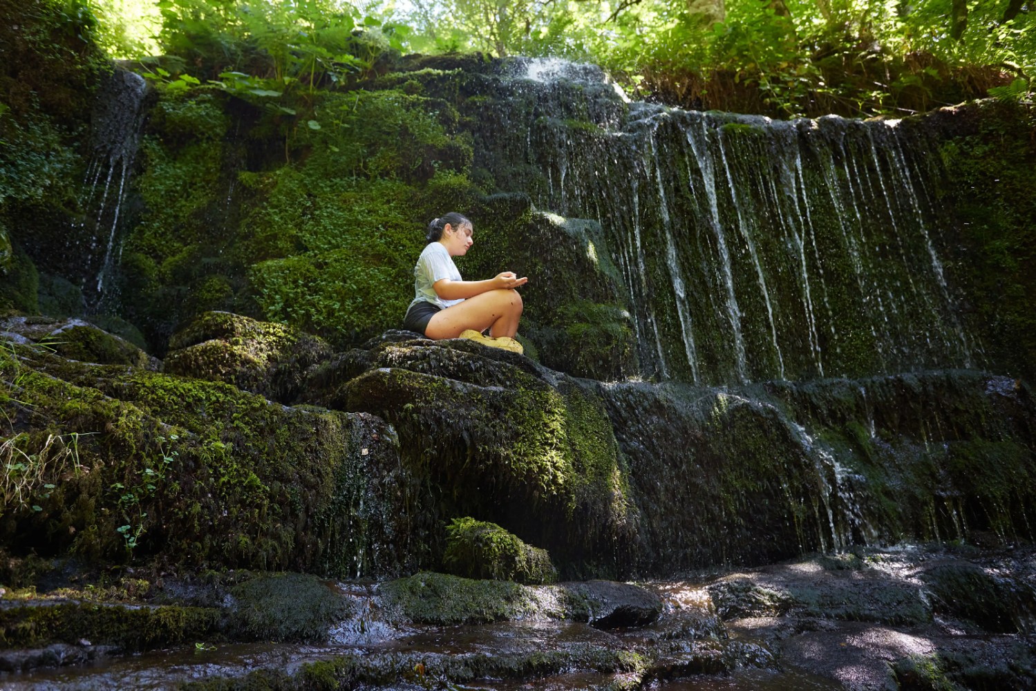 Persona sola meditando en una cascada, junto al centro de retiros de yoga pirineo